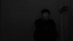 A black and white photo of a person sitting on the floor